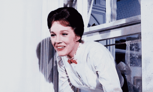 a woman in a white shirt with a red bow tie looks out a window