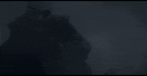 a black and white photo of a man in a helmet in the fog