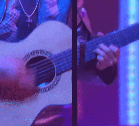 a close up of a person playing a guitar in front of a blue light .