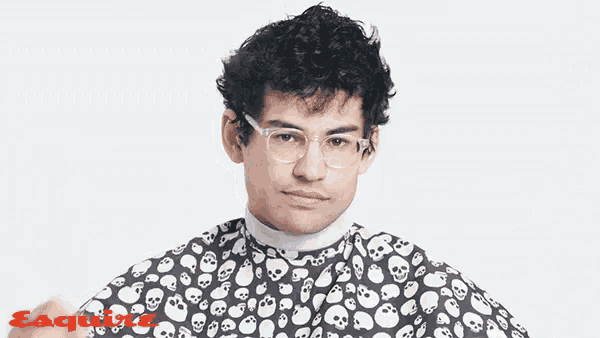 a man wearing glasses and a cape with skulls and the word esquire in red