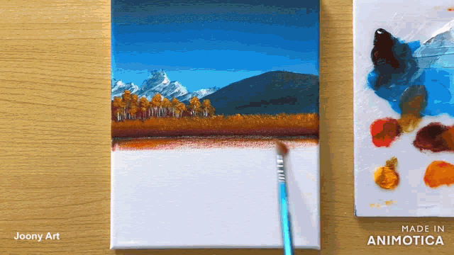 a painting of a mountain landscape is being painted on a canvas by joony art