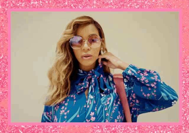 a woman wearing sunglasses and a blue floral top