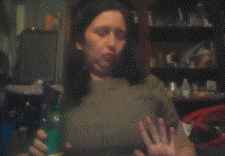 a woman wearing a green bra is taking off her shirt .