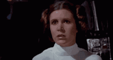 a close up of a woman 's face in a star wars movie with her hair in a ponytail .
