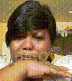 a woman with a nose ring is crying with her hand on her face
