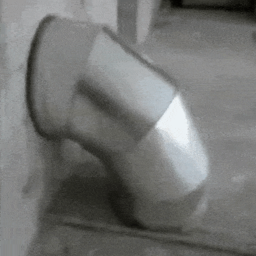 a black and white photo of a stainless steel pipe coming out of a wall .