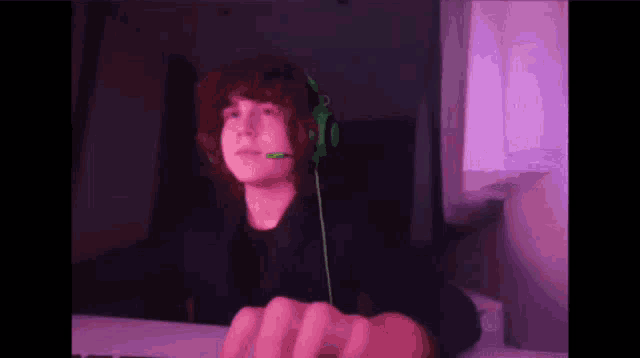 a young man wearing green headphones and a microphone