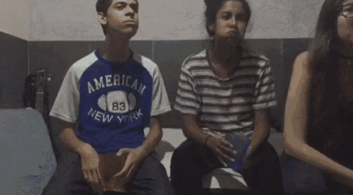 a boy wearing an american new york shirt sits next to a girl