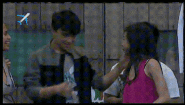 a woman in a pink tank top is talking to a man