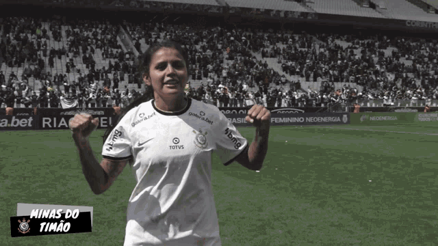 a female soccer player named minas do timao stands on a field