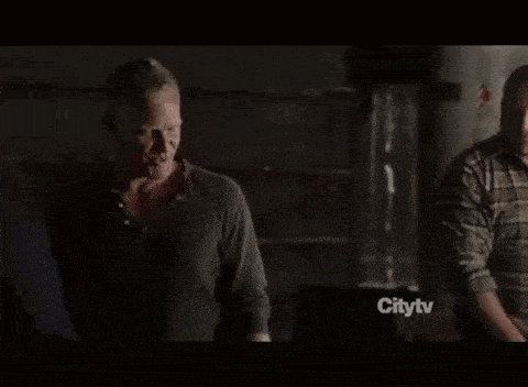 a man in a suit is being held by another man with a citytv advertisement in the background