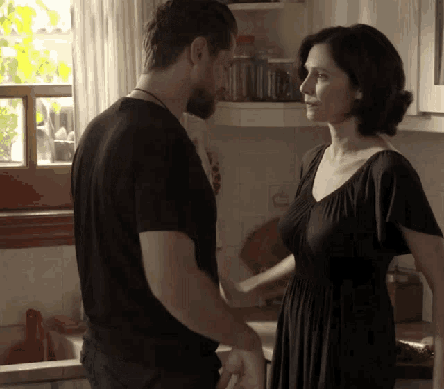 a man and a woman are holding hands in the kitchen