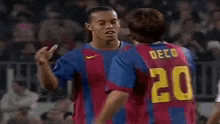 a soccer player wearing a number 20 jersey is hugging another player .