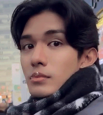a close up of a young man wearing a scarf .