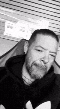 a man with a beard is sitting in a chair with his eyes closed .