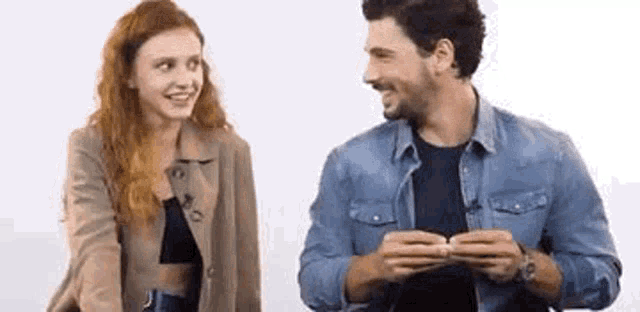 a man and a woman are sitting next to each other and smiling .