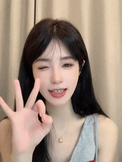 a young woman with long black hair is giving the ok sign