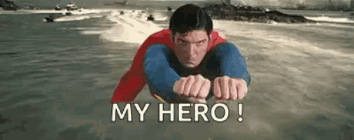 a man in a superman suit is flying through the air over a body of water .