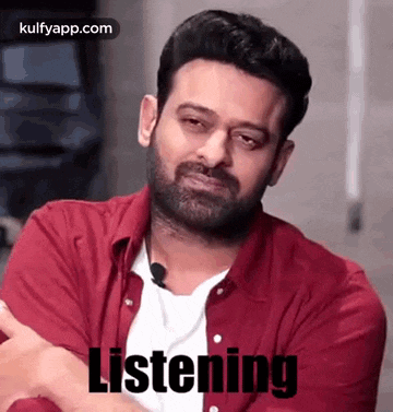 a man with a beard is wearing a red shirt and a white shirt .