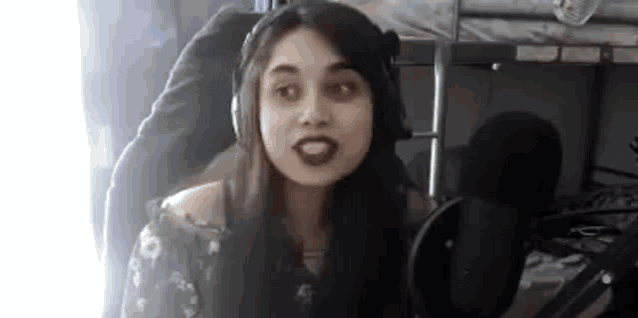 a woman wearing headphones is talking into a microphone .