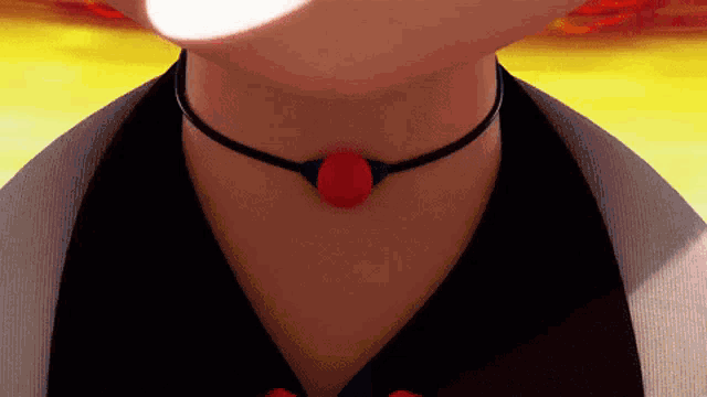 a close up of a person 's neck with a red pendant