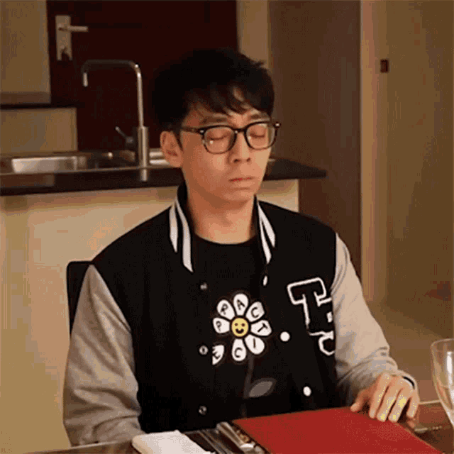 a man wearing glasses and a jacket with the letter p on it