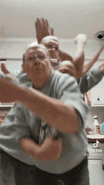 a man in a blue shirt is dancing in a kitchen with the hashtag tiktok