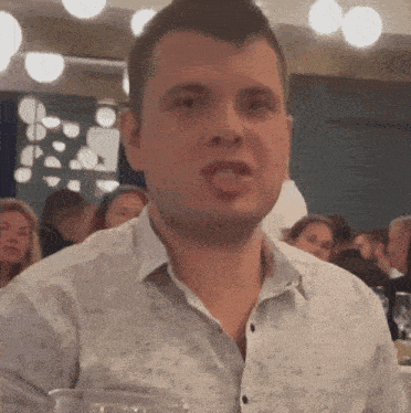 a man in a white shirt is sitting at a table