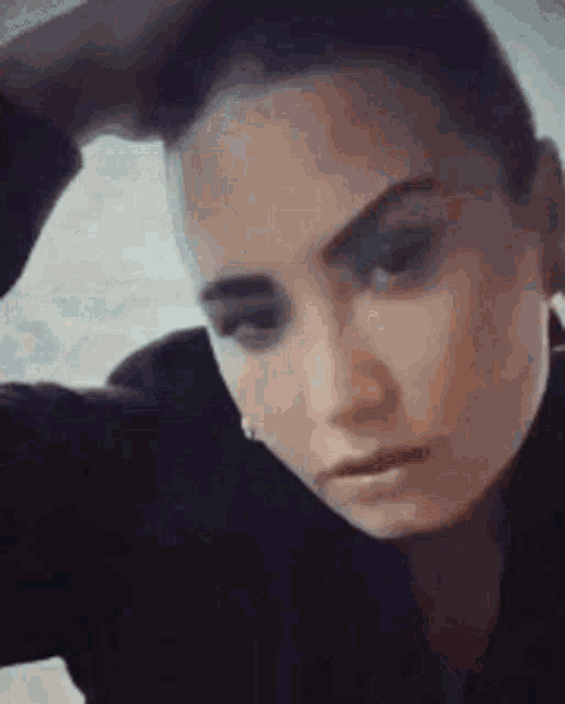a close up of a woman with her hand in her hair .