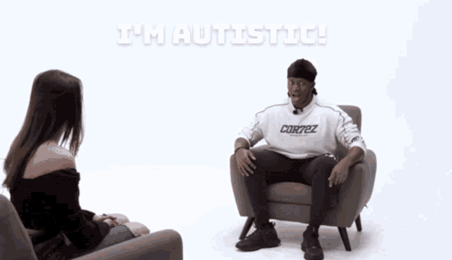 a woman sits next to a man who is sitting in a chair with his feet up and says i 'm autistic