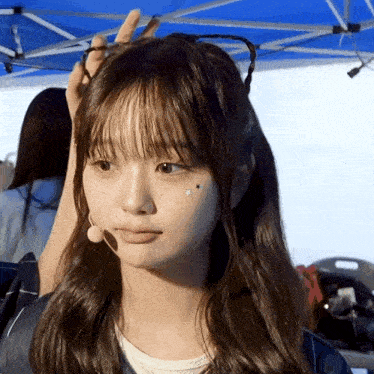 a girl with a microphone on her head has a star on her cheek