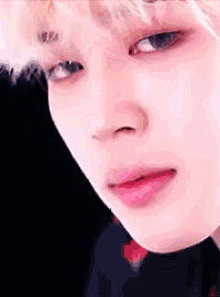 a close up of a person 's face with a black background and red lips .