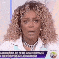 a woman with curly hair is wearing a necklace and earrings and making a surprised face .