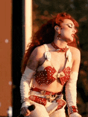 a woman with red hair is holding a microphone in her hand