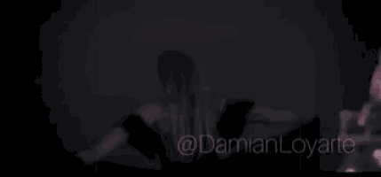 a woman is sitting on a couch in a room with pink smoke coming out of the couch .