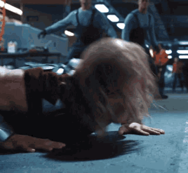 a person is crawling on the floor with a man standing behind them