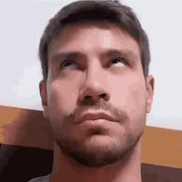 a man with a beard is making a funny face with his eyes closed .
