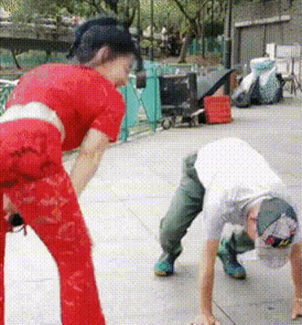 a woman in a red dress is standing next to a man in a white shirt on the ground .