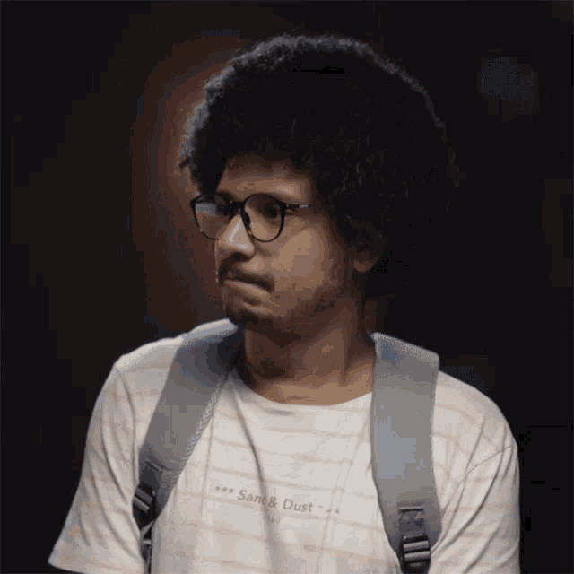 a man wearing glasses and a shirt that says " sans & dust "