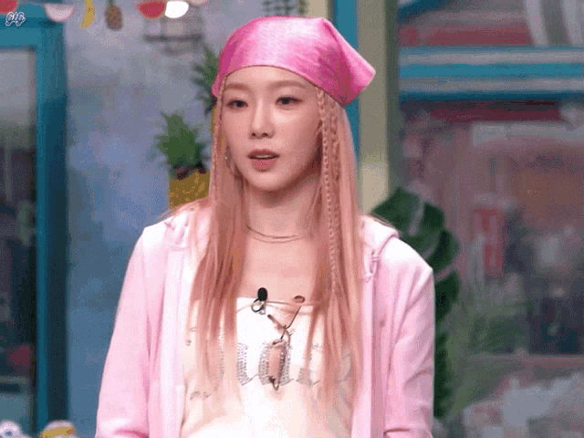 a woman wearing a pink jacket and a pink headband has the word vogue on her shirt