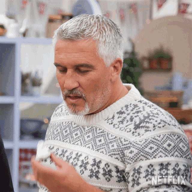 a man with gray hair and a beard is wearing a sweater that says netflix on it
