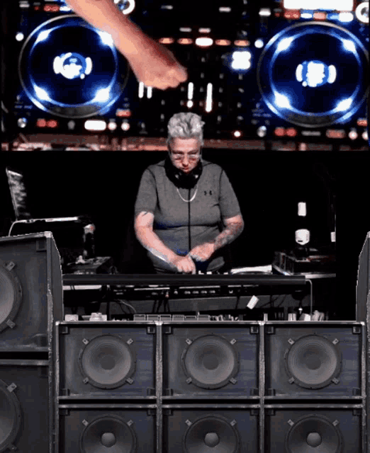 a man is playing music in front of a large stack of speakers
