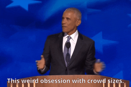 a man in a suit and tie stands at a podium with the words " this weird obsession with crowd sizes " above him
