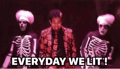a man in a suit and tie is standing in front of two skeletons and says `` everyday we lit ! ''