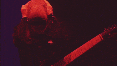 a woman with blonde hair is dancing in a dark room with purple lights .