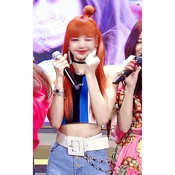 a woman with red hair is holding a microphone in her hands .