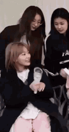 a group of young women are sitting next to each other and laughing .