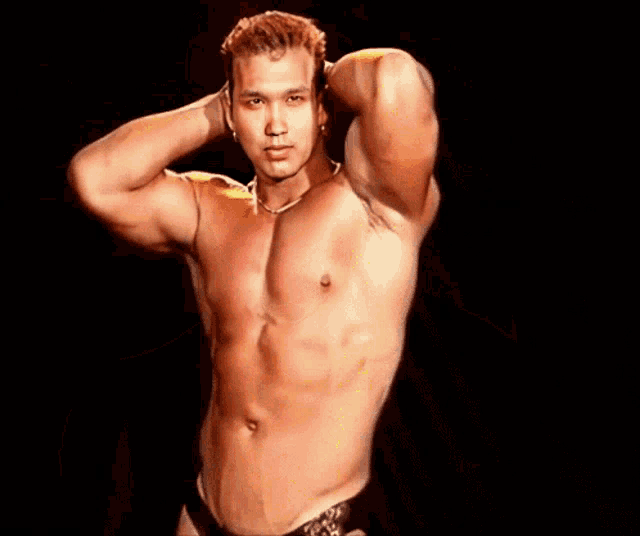 a shirtless man with a necklace around his neck