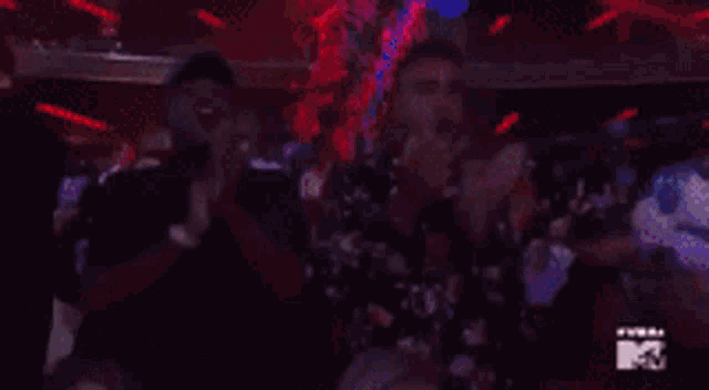 a woman in a white dress is dancing in front of a crowd at a concert .
