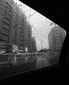 a black and white photo of rain drops on a car windshield
